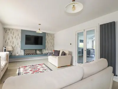 a living room with a white couch and a fireplace at Trenant View in Wadebridge