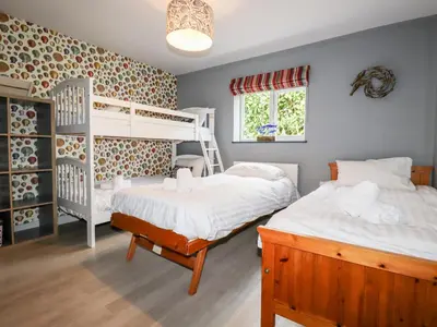 a bedroom with two beds and a bunk bed at Trenant View in Wadebridge