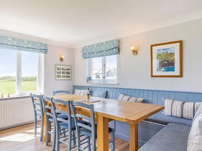 a dining room with a wooden table and chairs at Penhallick House in Tintagel