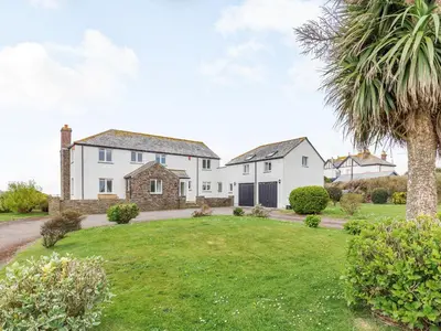 a large white house with a palm tree at Penhallick House in Tintagel