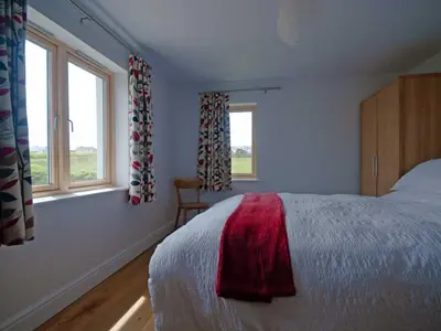 a bedroom with a bed and two windows at Kareena in Newquay