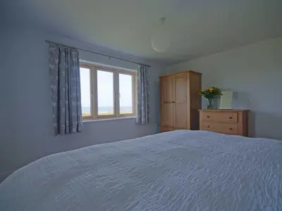 a bedroom with a large bed and a window at Kareena in Newquay