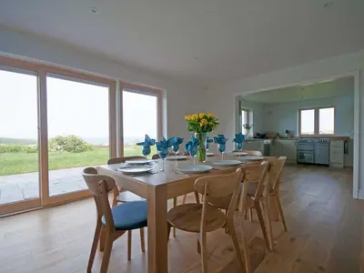 a dining room with a wooden table and chairs at Kareena in Newquay