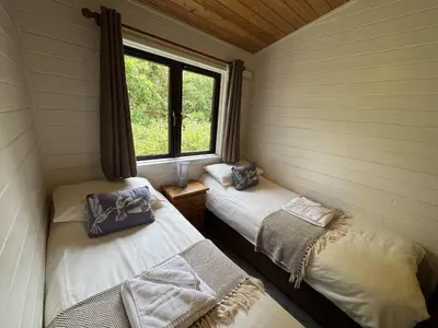 two beds in a room with a window at Willow Lodge in Falmouth