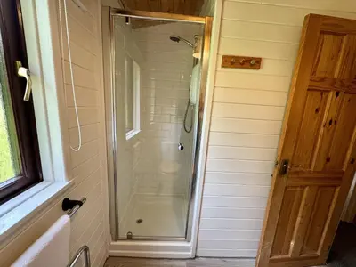 a shower with a glass door in a bathroom at Willow Lodge in Falmouth
