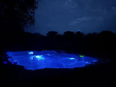 a lit up hot tub in the dark at night at Willow Lodge in Falmouth