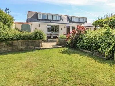 a house with a lawn in front of it at Woolly Welcome in Penzance