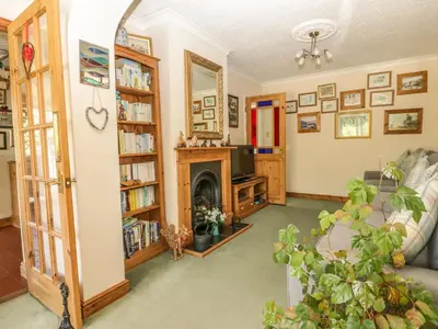 a living room with a fireplace and a tv at Woolly Welcome in Penzance