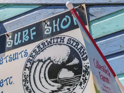 a sign on a building with a wave on it at Gull Rock in Tintagel