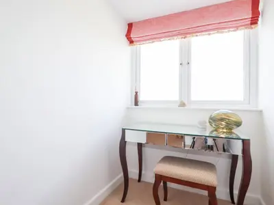 a desk and a chair in a room with a window at Seaspell Beach House in Padstow