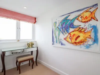 a bedroom with a painting of fishes on the wall at Seaspell Beach House in Padstow