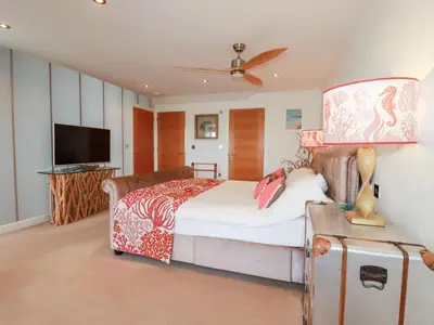 a bedroom with a bed and a flat screen tv at Seaspell Beach House in Padstow