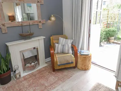 a living room with a chair and a fireplace at Tranquility in Falmouth