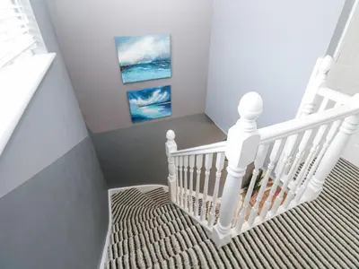 a staircase with a white rail and a painting at Tranquility in Falmouth