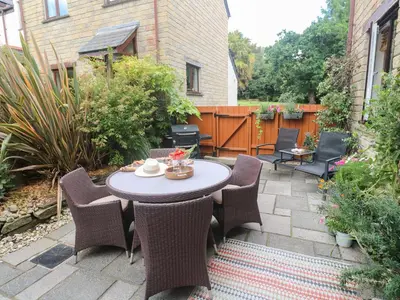 a patio with a table and chairs in a backyard at Tranquility in Falmouth