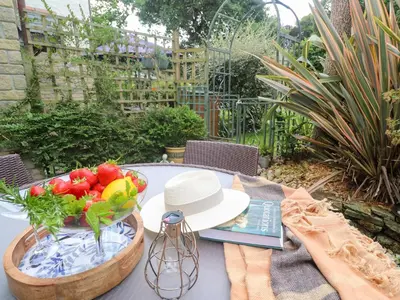 a table with a bowl of fruit and a hat on it at Tranquility in Falmouth