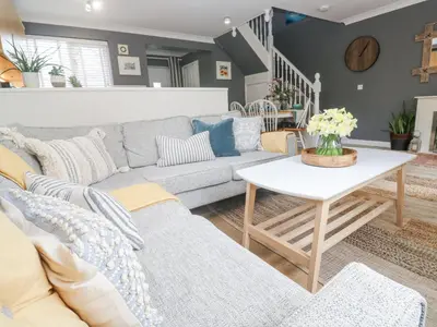 a living room with a couch and a table at Tranquility in Falmouth