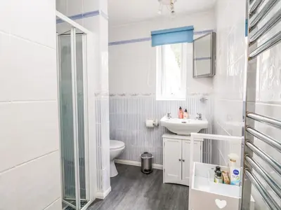 a white bathroom with a sink and a toilet at Little Westwards in Penzance