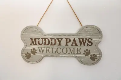a wooden sign that reads muddy paws welcome at Little Westwards in Penzance