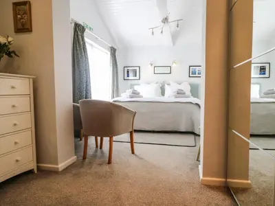 a bedroom with a bed and a chair at Little Westwards in Penzance