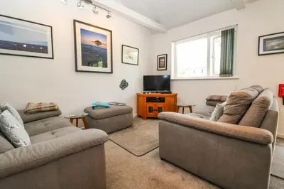 a living room with two couches and a tv at Little Westwards in Penzance