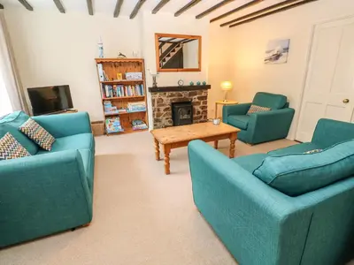 a living room with two blue couches and a fireplace at The Chace in Redruth