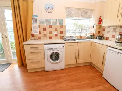 a kitchen with a washing machine and a sink at The Chace in Redruth
