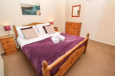 a bedroom with a large bed with a purple blanket at The Chace in Redruth