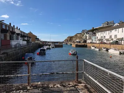 a group of boats in a river with buildings at The Chace in Redruth
