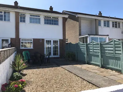 a house with a green fence and a patio at The Chace in Redruth