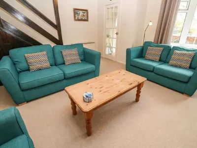 a living room with two green couches and a coffee table at The Chace in Redruth