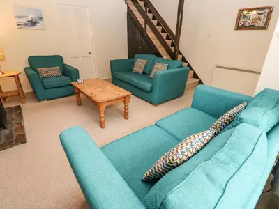 a living room with a blue couch and two chairs at The Chace in Redruth