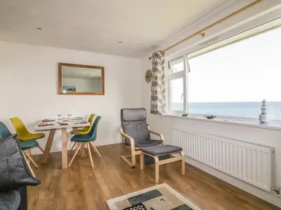 a dining room with a table and chairs and a window at Fistral Surf in Newquay