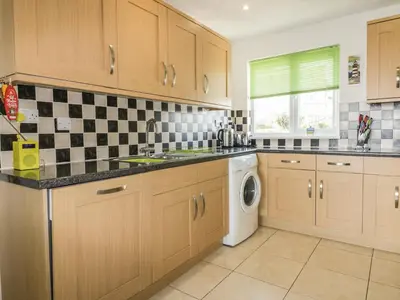 a kitchen with a sink and a washing machine at Fistral Surf in Newquay
