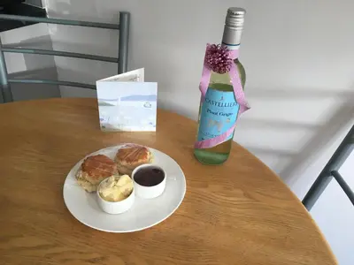 a table with a plate of food and a bottle of wine at Kiki’s Corner in Newquay