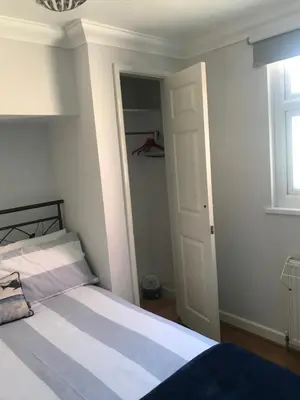 a bedroom with a bed and a window and a door at Kiki’s Corner in Newquay