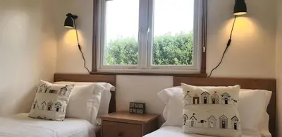 a bedroom with two beds and a window at Little Oaks Chalet - St. Merryn, Padstow in Padstow