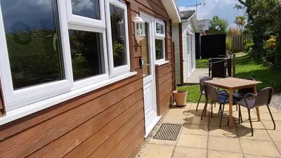 a patio with a table and chairs on a house at Little Oaks Chalet - St. Merryn, Padstow in Padstow