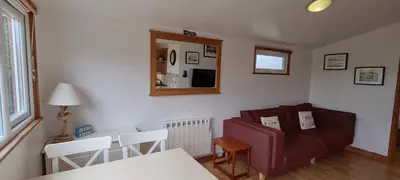 a living room with a couch and a table at Little Oaks Chalet - St. Merryn, Padstow in Padstow