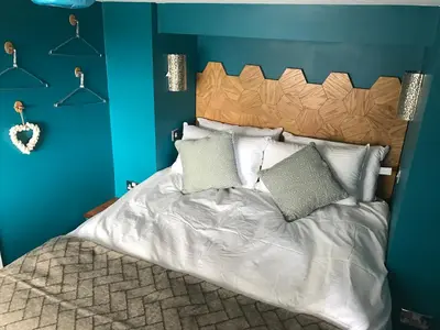 a bedroom with a bed with a blue wall at Fistral Hideaway in Newquay