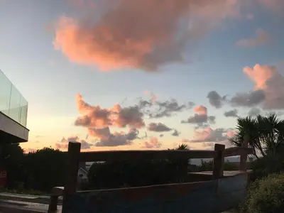 a cloudy sky with a bench in front of a building at Fistral Hideaway in Newquay