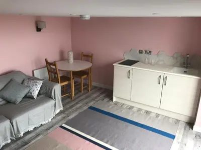 a living room with a couch and a table at Fistral Hideaway in Newquay