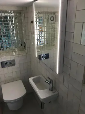 a bathroom with a sink and a toilet and a mirror at Fistral Hideaway in Newquay