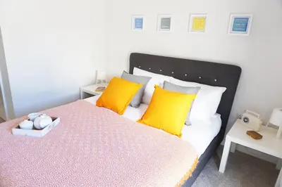 a bedroom with a large bed with yellow pillows at Stones Throw in Newquay