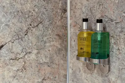 a green and yellow bottle of soap on a wall at Merrivale Barn in Constantine
