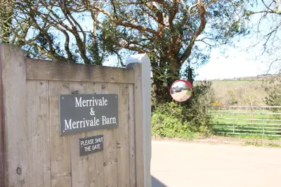 a sign on a wooden fence in front of a gate at Merrivale Barn in Constantine