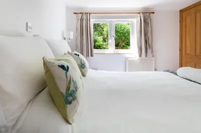 two white beds in a room with a window at Merrivale Barn in Constantine