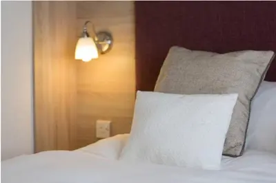 a bedroom with a bed with a pillow and a light at Blenheim, Padstow in Padstow