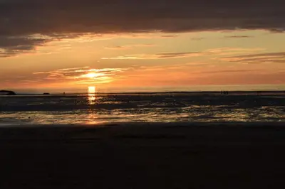 a sunset on the beach with the sun setting at Blenheim, Padstow in Padstow