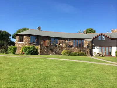 a large brick house with a lawn in front of it at Green Acres Cottages in Par